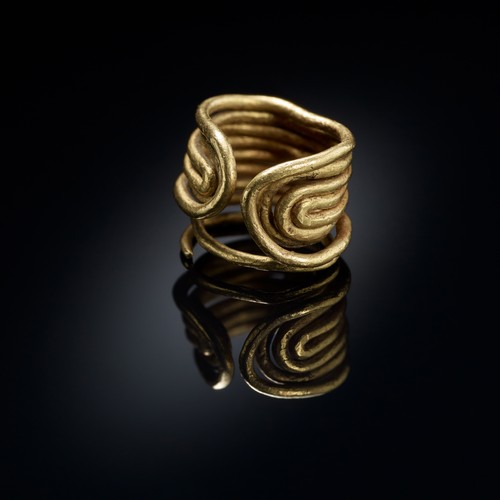 Goldener Ring aus mehreren rund geformten Golddrähten, die nebeneinanderliegen.