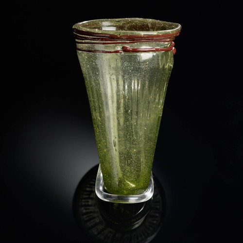 Unförmiger grüner Glasbecher, verziert mit einem roten Glasfaden an der Mündung.