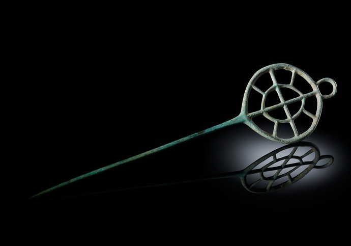 Nadel aus grüner Bronze, an einem Ende verziert mit einem doppelten Speichenrad