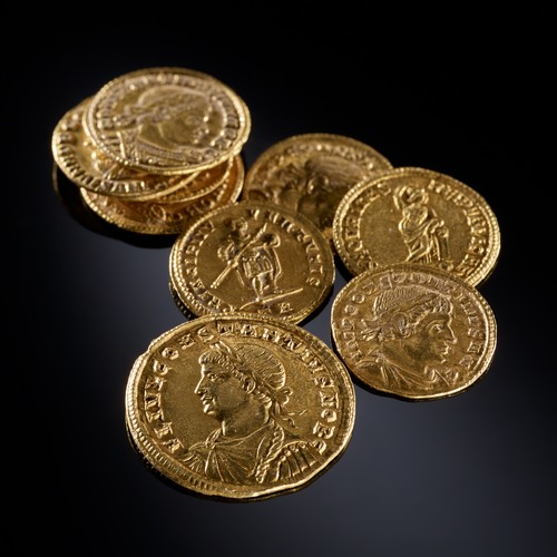 Neun römische Goldmünzen, die verschiedene Portraits und Figuren zeigen.